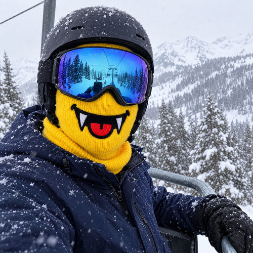 Skier on a chairlift in falling snow wearing the Maskot Fangs ski mask with helmet and goggles